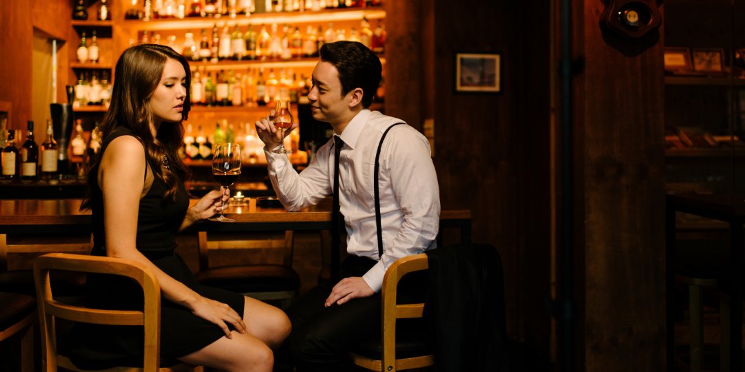 Mężczyzna i kobieta piją drinki w barze.