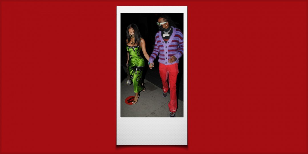 Raper Quavo chodzący i trzymający się za ręce ze swoją dziewczyną, Saweetie. Ma na sobie fioletowo-czerwony kardigan w paski, czarny T-shirt, czerwony je