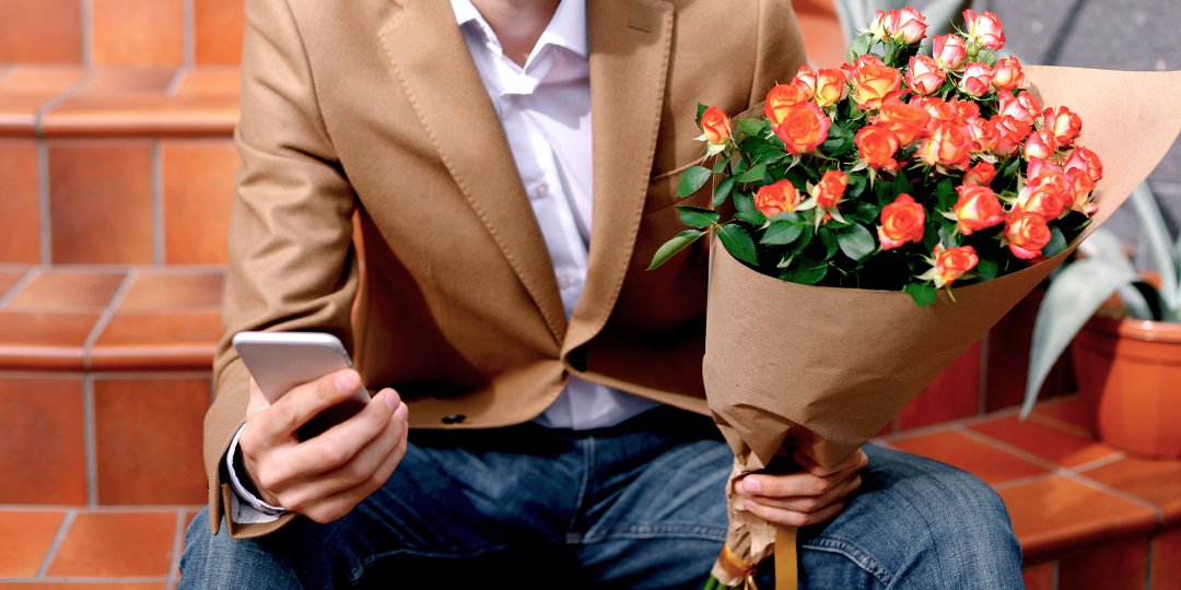 Człowiek z telefonem i kwiatami