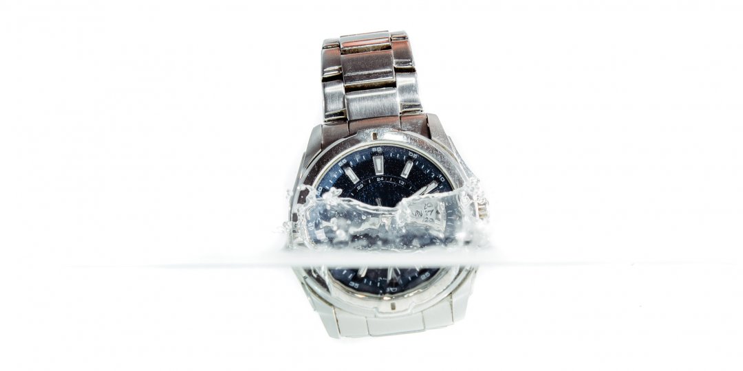 Stalowy zegarek wpadający pod wodę
