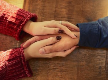 Przycięty wysoki kąt strzał mężczyzny i kobiety trzymających się za ręce na stole