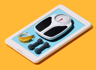 Sprzęt Fitness i waga na ekranie dotykowym smartfon na żółtym tle