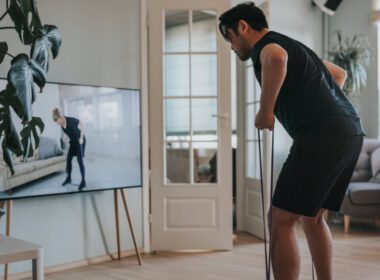 Mężczyzna biorący zajęcia fitness na tym telewizorze w domu