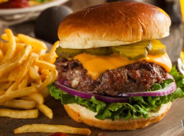 Burger, frytki i piwo na drewnianym blacie