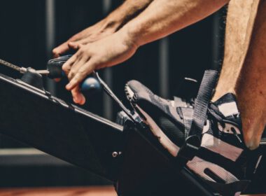 Zbliżenie rąk i stóp mężczyzny na wioślarzu
