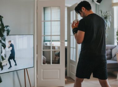 Mężczyzna podążający wraz z treningiem bokserskim na telewizorze w domu