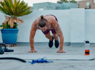 Mężczyzna robi trening burpee na dachu z narzędziami fitness