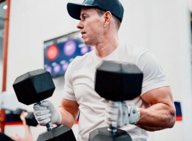 Mark Wahlberg ćwiczy z dwoma hantlami w siłowni F45.