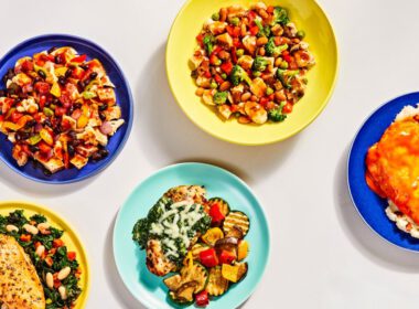 Widok z góry na pięć posiłków FreshlyFit platerowanych na kolorowych naczyniach.