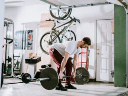 mężczyzna ćwiczący sztangę na domowej siłowni w garażu