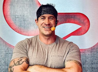 Bosman marynarki Rusty Babcock stoi przed logo CycleBar w Cyclebar Pensacola, gdzie jest kierownikiem studia I INST
