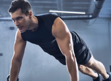 Athletic człowiek robi pompki ćwiczenia na siłowni